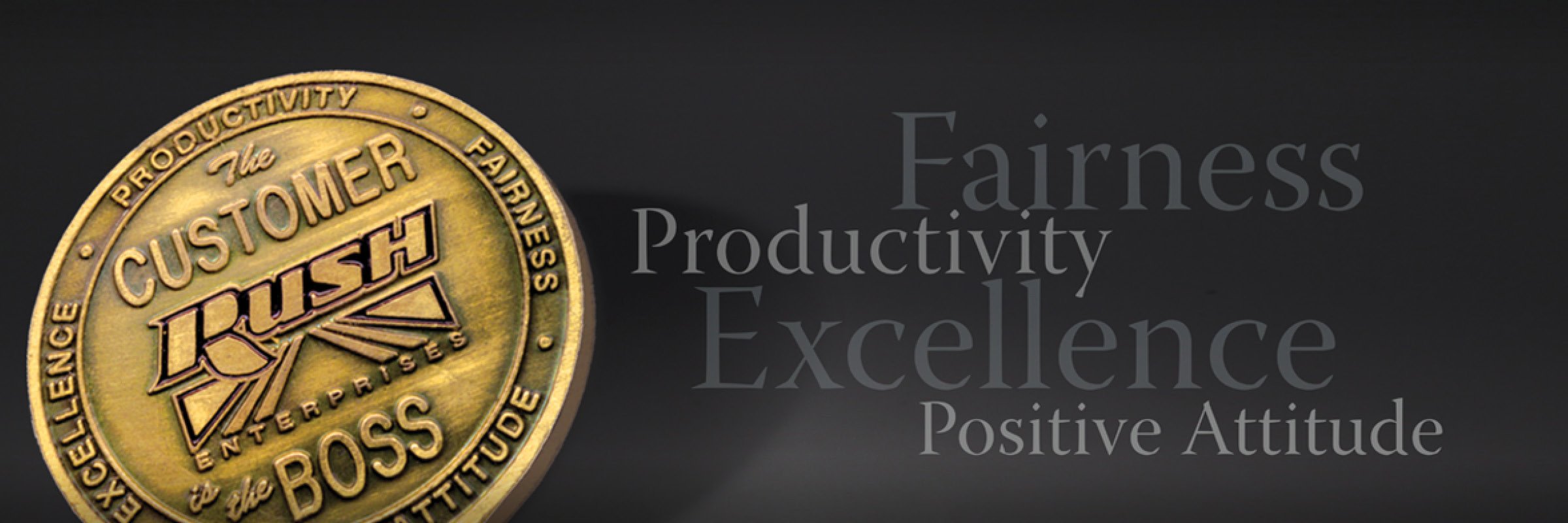 Rush Truck Centers coin with the words Fairness, Productivity, Excellence and Positive Attitude to the right