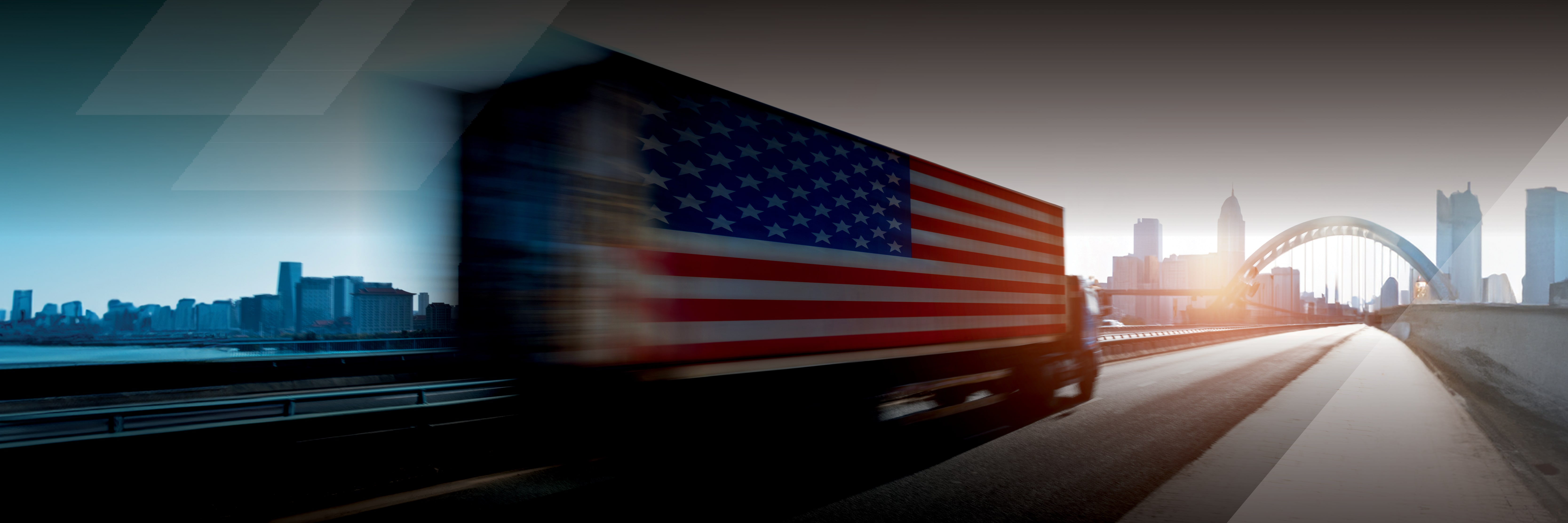 Semi truck with American flag on its trailer driving down highway
