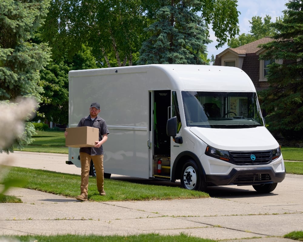 Delivery driver walking away from Blue Arc Class 4 walk-in van